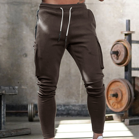 Braune Jogginghose für Herren im Fitnessstudio, mit Kordelzug und Seitentaschen. Ideal für Sport und Freizeit. Bequeme und stylische Sportbekleidung.