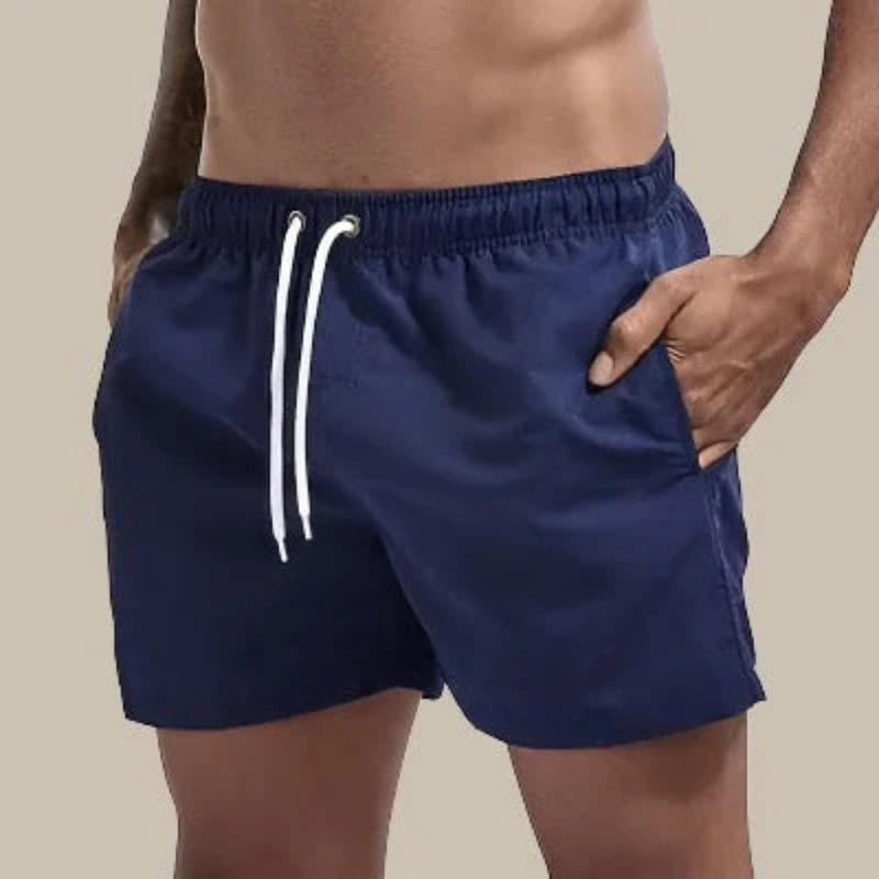 Laden Sie das Bild in Galerie -Viewer, Dunkelblaue Herren-Badeshorts mit weißem Kordelzug, elastischem Bund und Seitentaschen. Ideal für Strand und Schwimmen.
