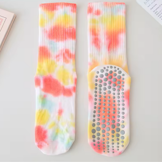 Bunte rutschfeste Socken mit Batikmuster in Rot, Gelb und Blau auf weißem Hintergrund. Ideal für Yoga, Fitness und Freizeit.