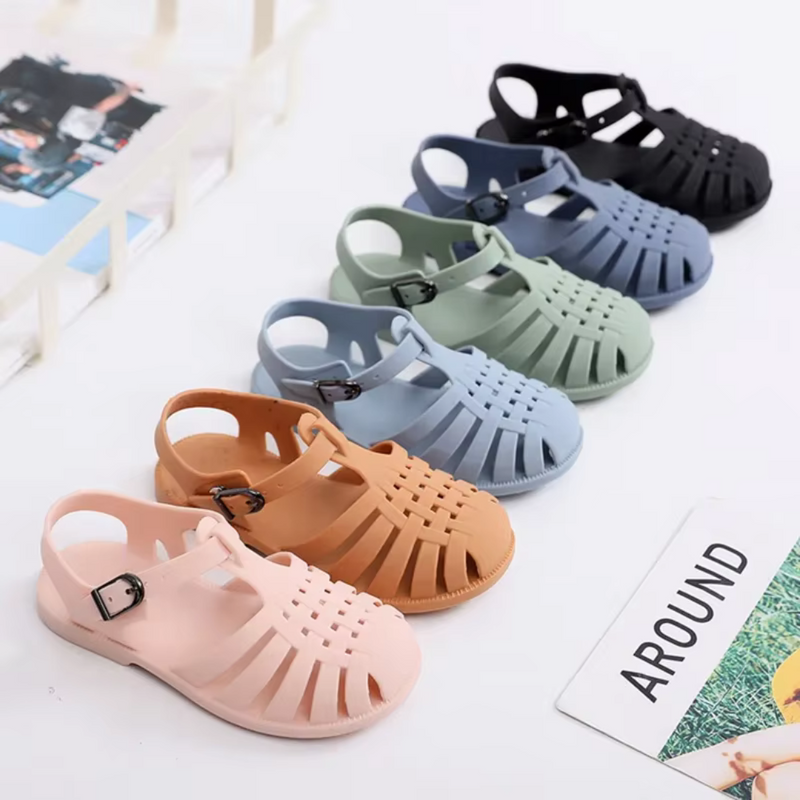 Laden Sie das Bild in Galerie -Viewer, Sechs Paar Kinder-Sandalen in verschiedenen Farben (Rosa, Beige, Grün, Blau, Grau, Schwarz) auf weißem Hintergrund. Ideal für Sommermode.
