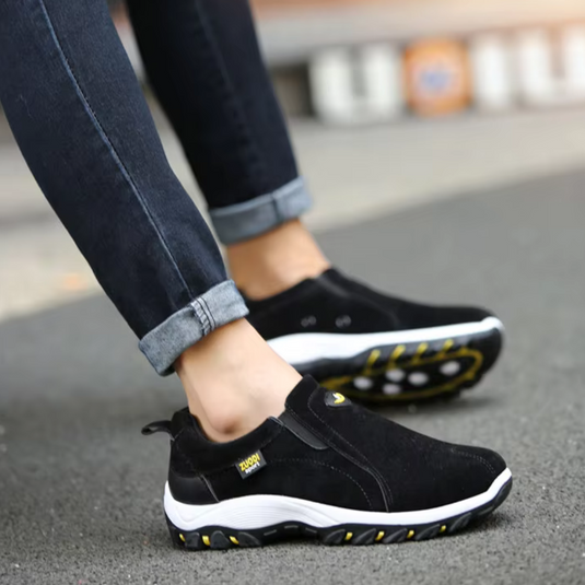 Schwarze Herren-Sneaker mit weißer Sohle, getragen auf Asphalt. Bequeme, sportliche Schuhe für Freizeit und Outdoor-Aktivitäten.
