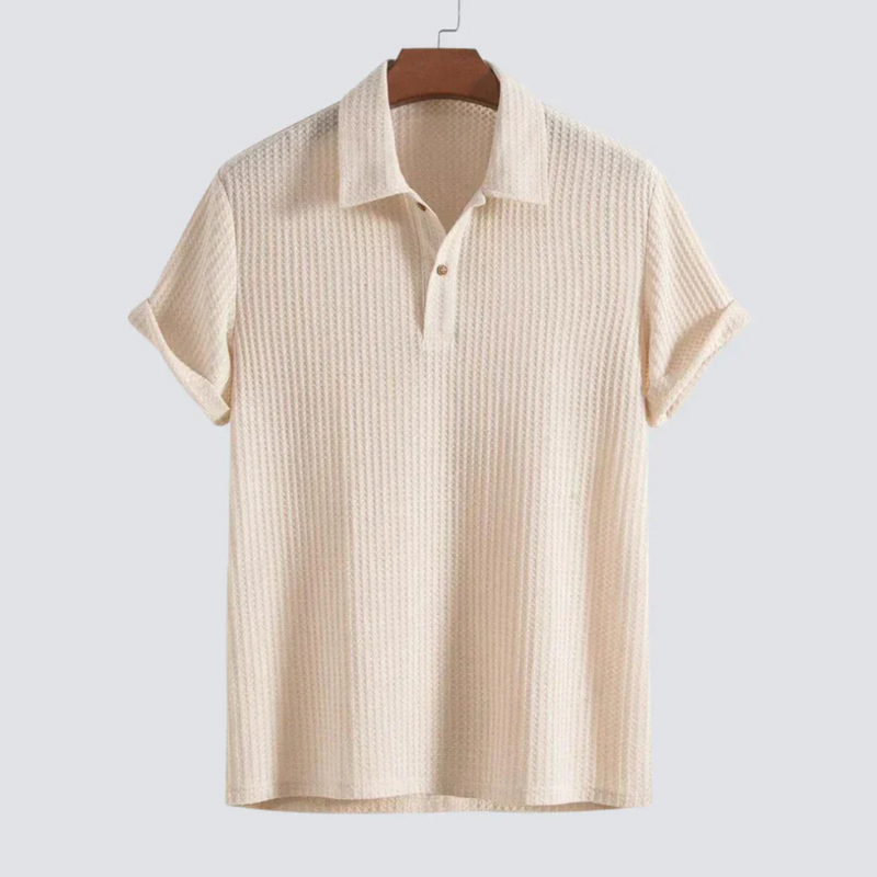 Laden Sie das Bild in Galerie -Viewer, Beiges Herren-Poloshirt aus Baumwolle, kurzärmelig, mit Knopfleiste, auf Holzbügel. Ideal für Sommermode und Freizeitkleidung.
