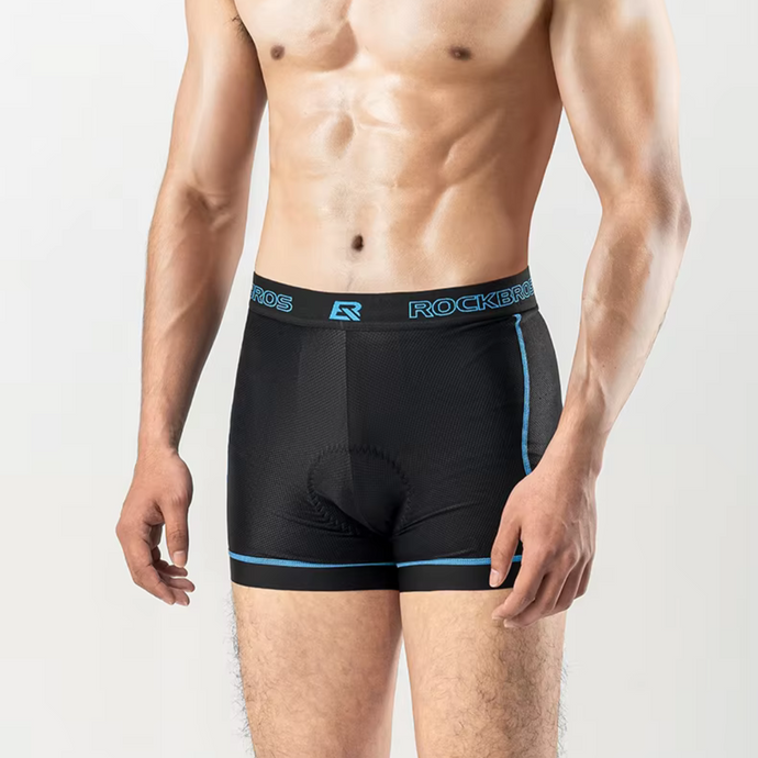 Mann in schwarzer, gepolsterter Radunterhose von ROCKBROS, ideal für Radsport, mit blauen Akzenten, vor grauem Hintergrund.