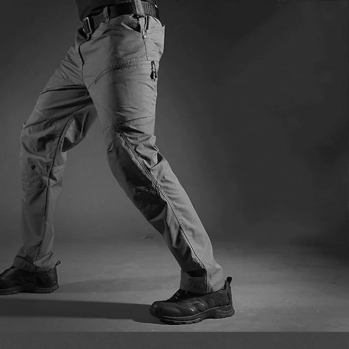 Graue taktische Hose für Herren, robust und strapazierfähig, mit mehreren Taschen, ideal für Outdoor-Aktivitäten und Abenteuer.