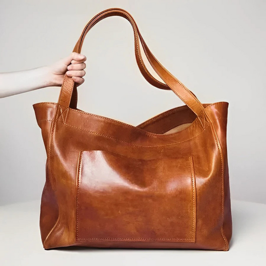 Braune Ledertasche mit großem Hauptfach und doppelten Tragegriffen, handgehalten. Hochwertige, stilvolle Damenhandtasche aus Echtleder.