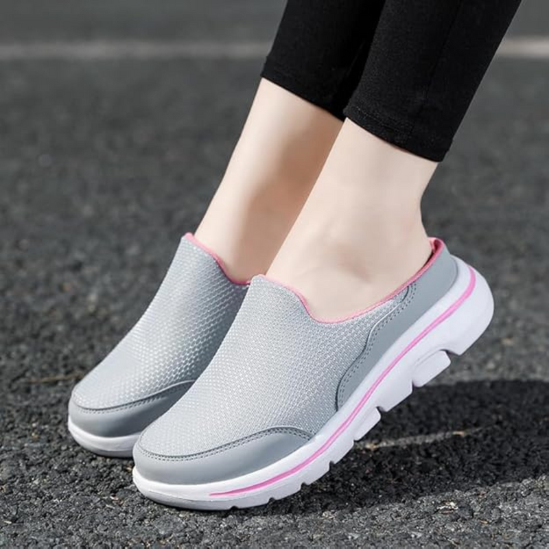 Laden Sie das Bild in Galerie -Viewer, Graue Damen-Sneaker mit rosa Akzenten auf Asphalt. Bequeme, atmungsaktive Freizeitschuhe, ideal für Spaziergänge und Alltag.
