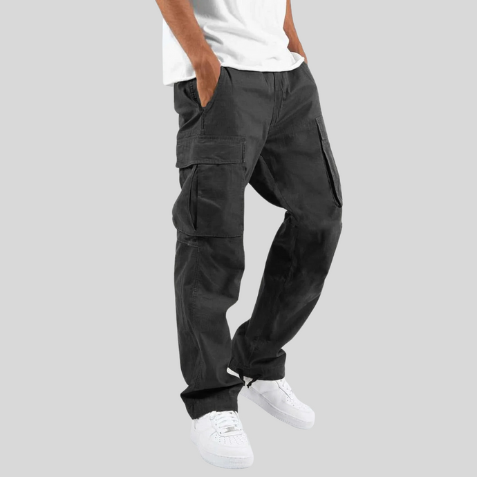 Schwarze Cargo-Hose für Herren, lässiger Stil, mit Seitentaschen, kombiniert mit weißem T-Shirt und weißen Sneakers, modische Freizeitkleidung.