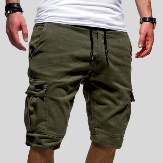 Mann trägt olivgrüne Cargo-Shorts mit Taschen und Kordelzug, kombiniert mit weißem T-Shirt. Modische Sommerbekleidung für Herren.