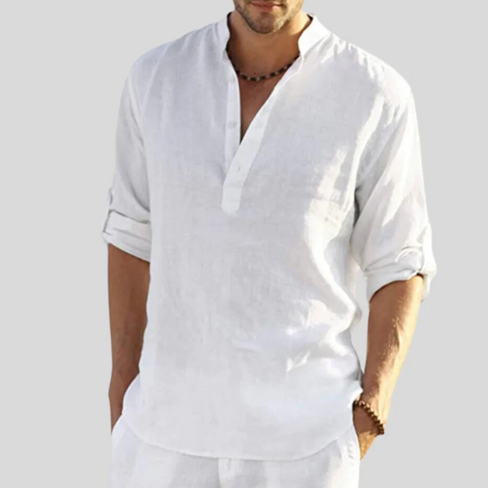 Mann in weißem Leinenhemd mit Stehkragen und hochgekrempelten Ärmeln. Sommermode, lässiger Stil, Herrenbekleidung, elegantes Design.