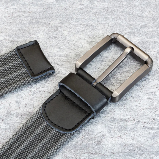 Grauer gewebter Gürtel mit schwarzer Lederschnalle auf grauem Hintergrund. Moderner Herrengürtel, stilvolles Accessoire, hochwertige Materialien.