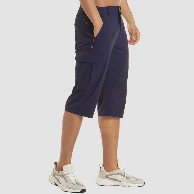 Laden Sie das Bild in Galerie -Viewer, Mann trägt dunkelblaue Cargo-Shorts und weiße Sneakers, seitliche Ansicht. Moderne Herrenmode, bequeme Sommerkleidung, sportlicher Stil.
