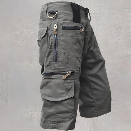 Graue taktische Cargoshorts mit mehreren Reißverschlusstaschen und D-Ring, ideal für Outdoor-Aktivitäten und Wandern. Robustes Design, funktional.