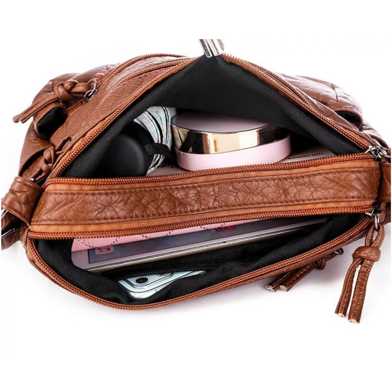 Laden Sie das Bild in Galerie -Viewer, Offene braune Lederhandtasche mit Reißverschluss, gefüllt mit Smartphone, Kosmetik und Notizbuch. Damenmode, Accessoires, praktische Handtasche.
