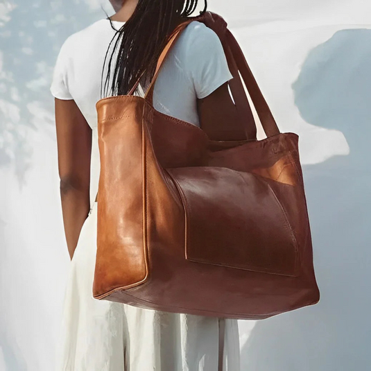 Frau mit großer brauner Ledertasche, modisch, elegant, nachhaltige Mode, Damenaccessoire, hochwertiges Leder, stilvoller Look.