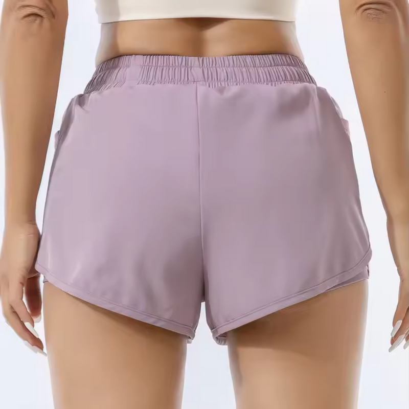 Laden Sie das Bild in Galerie -Viewer, Frau in lila Sportshorts von hinten, elastischer Bund, atmungsaktives Material, ideal für Fitness und Laufen. Sportbekleidung Damen.
