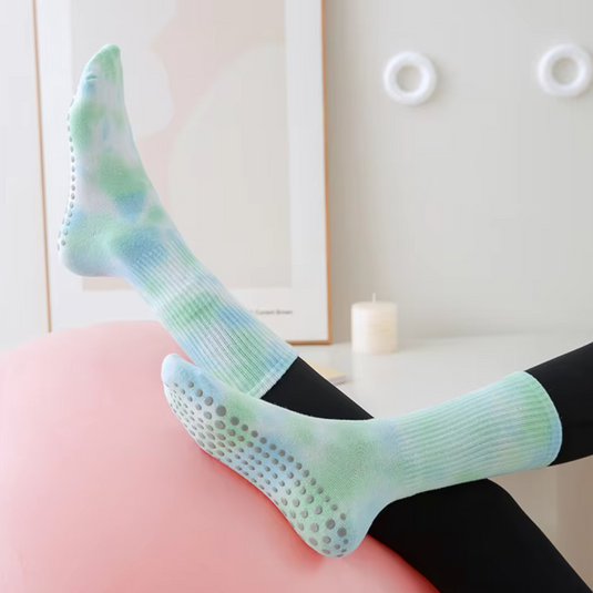 Bunte rutschfeste Socken auf Sofa, pastellfarben, ideal für Yoga oder Pilates. Bequeme, stilvolle Socken für Sport und Freizeit.