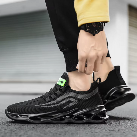 Schwarzer Sneaker mit innovativer Sohle, getragen von Person in gelbem Pullover. Moderner Sportschuh, ideal für Laufen und Freizeit.