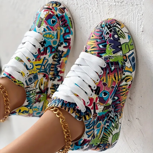 Bunte Sneaker mit Graffiti-Design, weiße Schnürsenkel, goldene Knöchelketten. Modische Turnschuhe, Streetwear, trendige Schuhe.