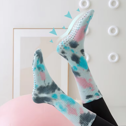 Bunte rutschfeste Socken mit blau-pinkem Batikmuster, ideal für Yoga oder Pilates, auf hellem Hintergrund. Bequeme, stilvolle Sportbekleidung.