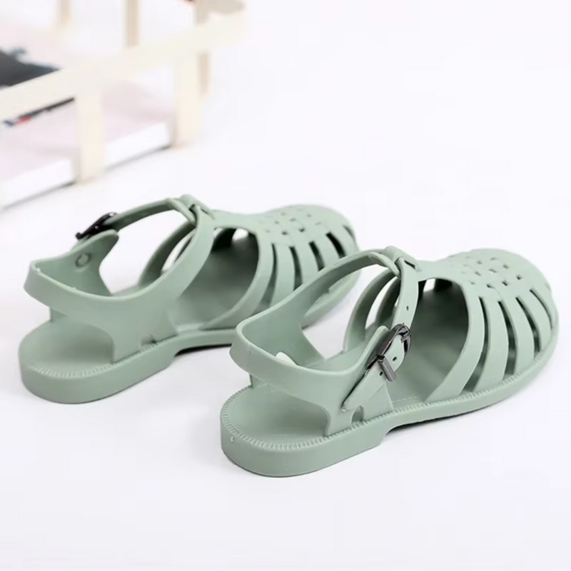 Laden Sie das Bild in Galerie -Viewer, Grüne Gummisandalen mit Riemen und Schnalle auf weißem Hintergrund. Modische, bequeme Sommerschuhe für Damen und Herren.
