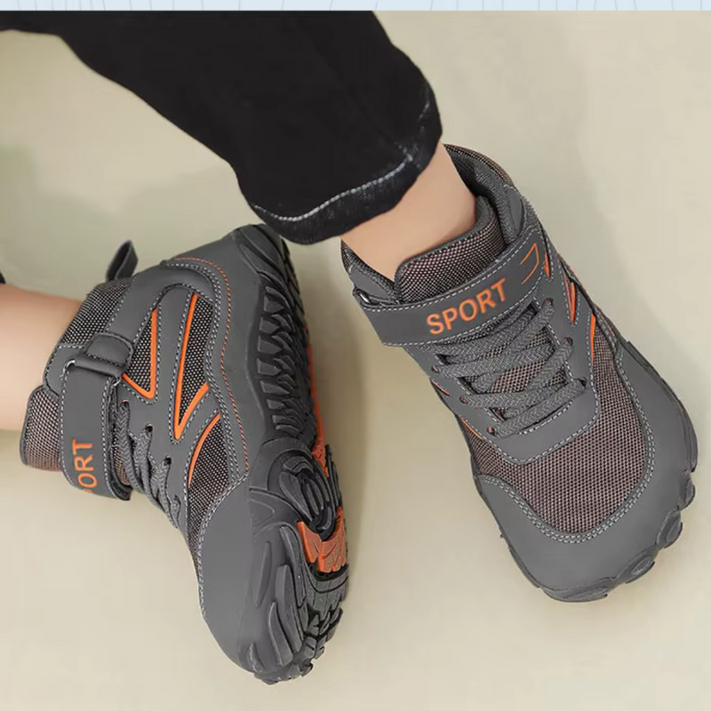 Laden Sie das Bild in Galerie -Viewer, Graue Kinderschuhe mit orangefarbenen Akzenten, Klettverschluss und rutschfester Sohle. Ideal für Outdoor-Aktivitäten und Sport.
