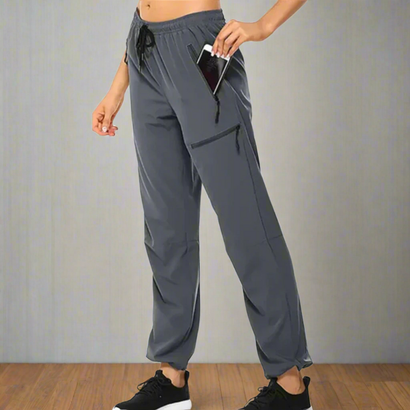 Laden Sie das Bild in Galerie -Viewer, Damen Jogginghose mit Taschen, dunkelgrau, elastischer Bund, ideal für Sport und Freizeit, Smartphone in Seitentasche, bequeme Passform.
