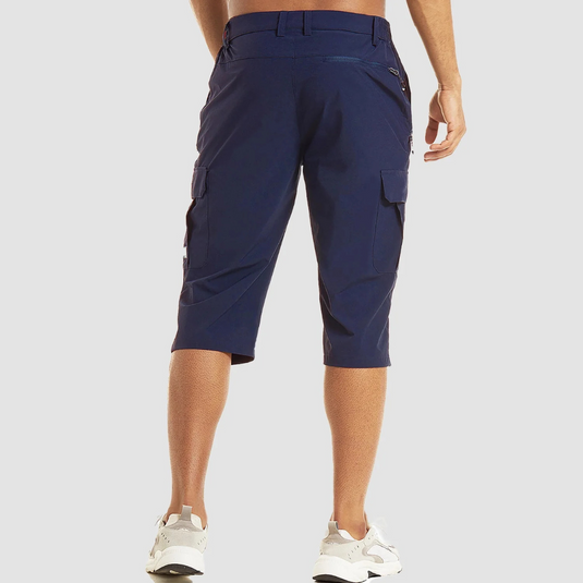 Mann in blauer, knielanger Cargo-Shorts von hinten, sportliche weiße Sneaker, lässiger Sommerlook, Outdoor-Mode, Herrenbekleidung.