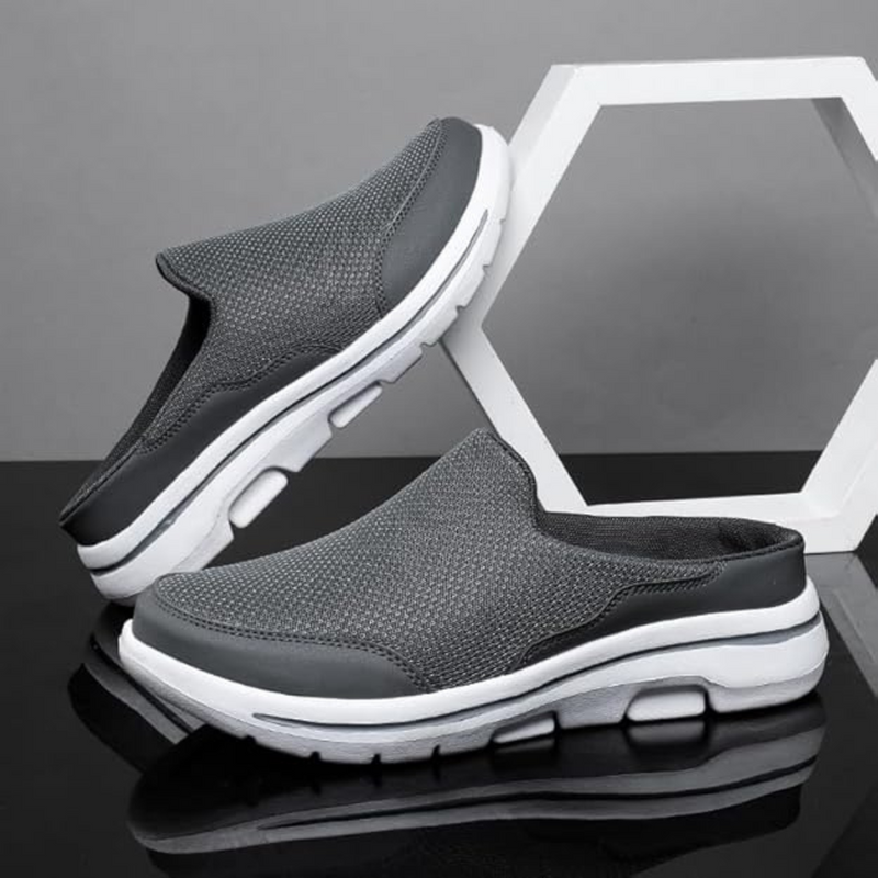 Laden Sie das Bild in Galerie -Viewer, Graue Herren-Sneaker-Slipper mit weißer Sohle, atmungsaktivem Mesh-Obermaterial, auf schwarzem und grauem Hintergrund, modisch und bequem.
