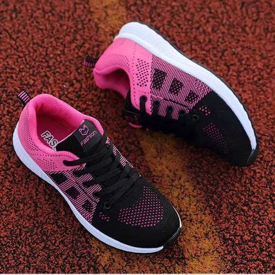 Schwarze und pinke Laufschuhe auf rotem Asphalt, sportliches Design, atmungsaktives Material, ideal für Damen, Fitness und Outdoor-Aktivitäten.