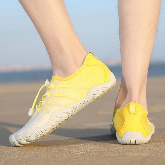 Gelbe Barfußschuhe für Herren auf Asphalt, ideal für Laufen und Outdoor-Aktivitäten. Leichtes Design, flexible Sohle, atmungsaktives Material.