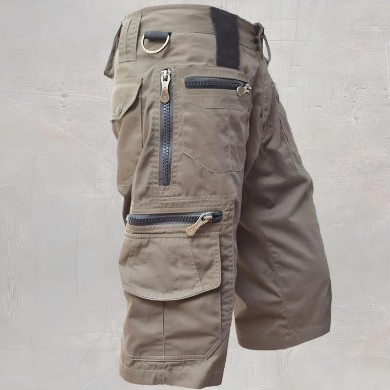 Laden Sie das Bild in Galerie -Viewer, Cargo-Shorts in Khaki mit mehreren Reißverschlusstaschen, robustem Stoff und praktischen Details, ideal für Outdoor-Aktivitäten und Freizeitkleidung.
