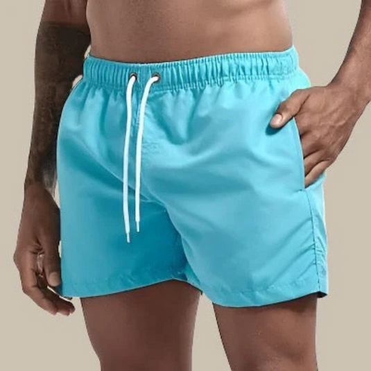 Mann in türkisfarbener Badehose mit Kordelzug, Hand in der Tasche. Sommermode, Strandbekleidung, Herrenbadehose, Freizeitlook.