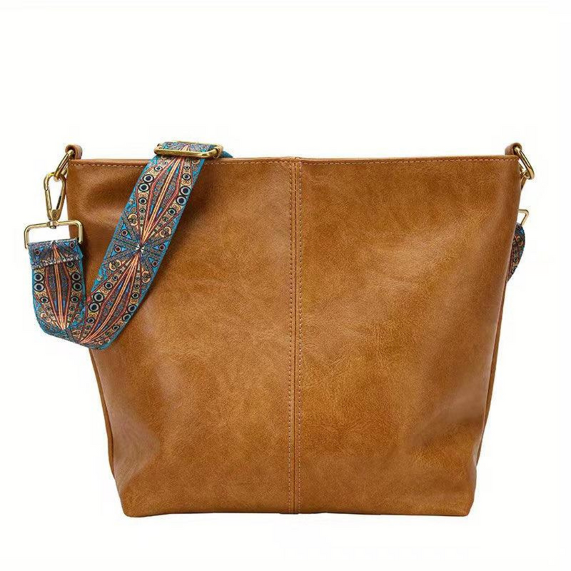 Laden Sie das Bild in Galerie -Viewer, Braune Ledertasche mit verziertem, blauem Schultergurt. Modische Damenhandtasche, ideal für Alltag und Freizeit. Hochwertiges Accessoire.
