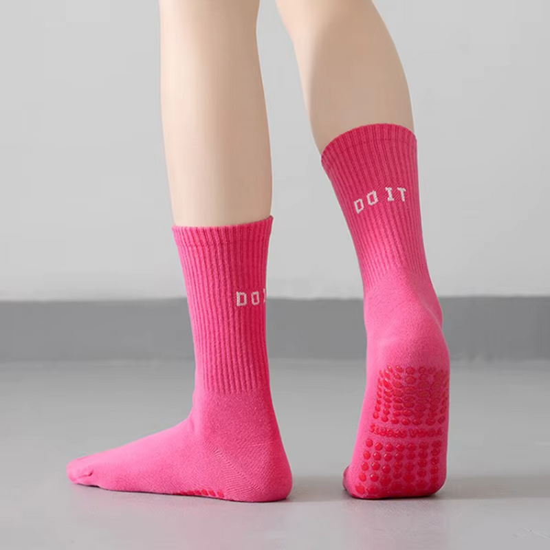 Laden Sie das Bild in Galerie -Viewer, Rosa rutschfeste Socken mit &quot;DO IT&quot; Schriftzug, ideal für Yoga oder Pilates. Bequeme, griffige Socken auf grauem Boden.
