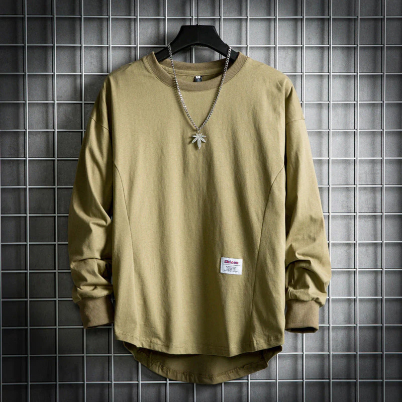 Laden Sie das Bild in Galerie -Viewer, Olivgrünes Langarmshirt auf Gitterhintergrund, verziert mit silberner Halskette und Blattanhänger. Modetrend, Streetwear, Herrenbekleidung.
