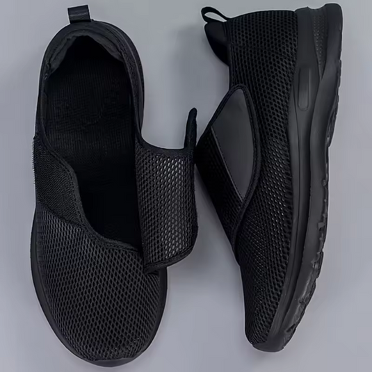 Schwarze, atmungsaktive Mesh-Sneaker mit Klettverschluss, seitlich und von oben gezeigt. Bequeme, rutschfeste Freizeitschuhe für Herren.
