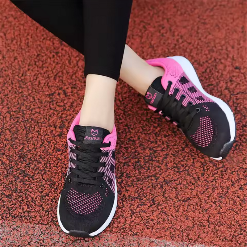 Laden Sie das Bild in Galerie -Viewer, Schwarze und pinke Damen-Laufschuhe auf rotem Asphalt, sportlich, bequem, ideal für Fitness und Jogging. Trendige Sportschuhe für Frauen.
