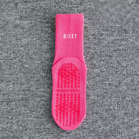 Einzelne pinke Yogasocke mit rutschfester Sohle und "DO IT"-Aufschrift auf grauem Hintergrund. Ideal für Yoga und Pilates.