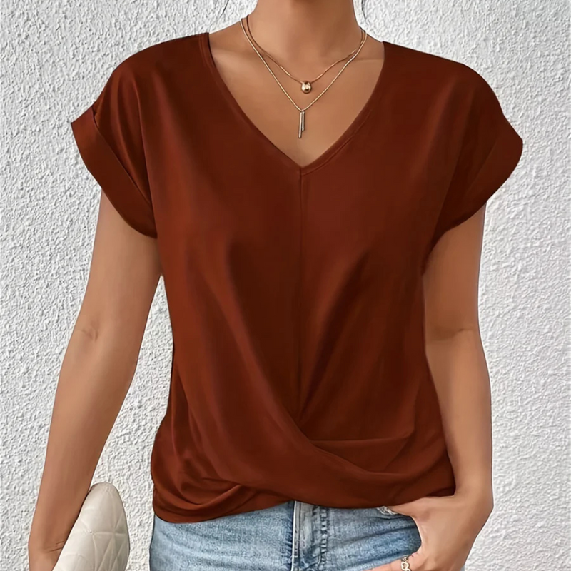 Laden Sie das Bild in Galerie -Viewer, Damenmode: Frau trägt braunes V-Ausschnitt-Shirt, kombiniert mit blauer Jeans und Halskette. Stilvoller Freizeitlook für den Sommer.
