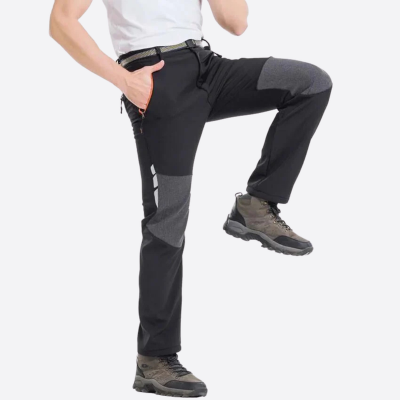 Laden Sie das Bild in Galerie -Viewer, Mann in Outdoor-Hose mit verstärkten Knien, schwarzer Farbe, trägt Wanderschuhe. Ideal für Trekking und Outdoor-Aktivitäten.
