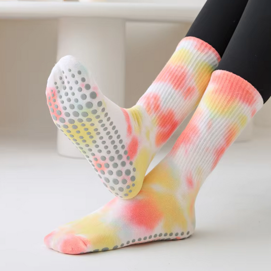 Bunte rutschfeste Socken mit Batikmuster auf weißem Hintergrund. Ideal für Yoga oder Pilates. Komfortable, farbenfrohe Socken mit Anti-Rutsch-Noppen.