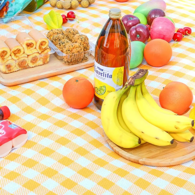 Laden Sie das Bild in Galerie -Viewer, Picknickdecke mit Bananen, Orangen, Saftflasche, Gebäck und buntem Obst. Sommerpicknick, frisches Obst, gesunde Snacks, Outdoor-Essen.

