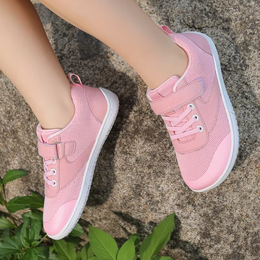 Rosa Kinderschuhe mit Klettverschluss und Schnürsenkeln auf Felsen, Outdoor, bequem, modisch, Kinder Sneaker, Freizeit, Frühling, Sommer.