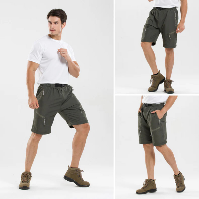 Laden Sie das Bild in Galerie -Viewer, Mann in olivgrünen Outdoor-Shorts mit Reißverschlusstaschen, weißem T-Shirt und braunen Wanderschuhen. Ideal für Trekking und Freizeitaktivitäten.
