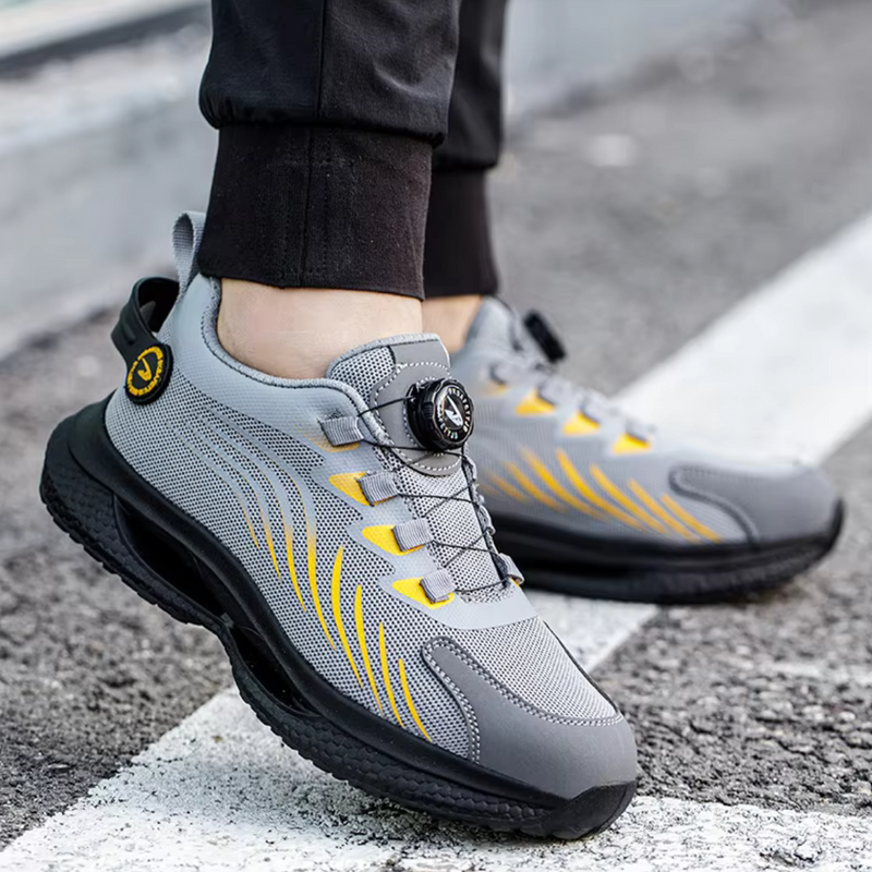Laden Sie das Bild in Galerie -Viewer, Graue Sportschuhe mit gelben Akzenten und Drehverschluss auf Asphalt. Moderne, atmungsaktive Sneakers für Herren, ideal für Laufen und Freizeit.
