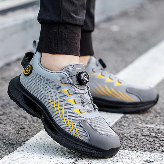 Graue Sportschuhe mit gelben Akzenten und Drehverschluss auf Asphalt. Moderne, atmungsaktive Sneakers für Herren, ideal für Laufen und Freizeit.