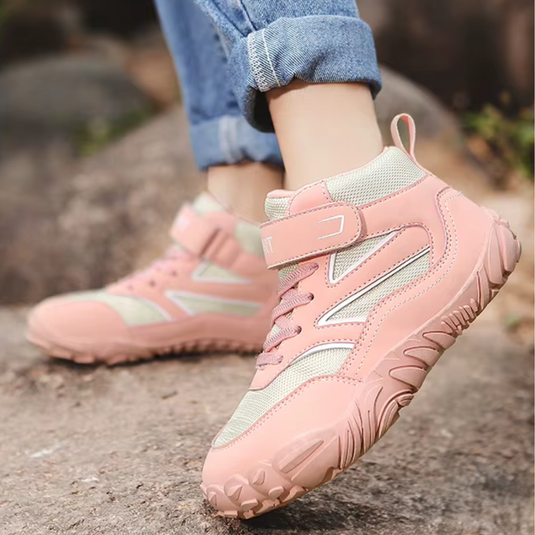 Damen-Wanderschuhe in Rosa und Beige auf Felsen, robustes Design, rutschfeste Sohle, ideal für Outdoor-Aktivitäten, bequeme Passform.