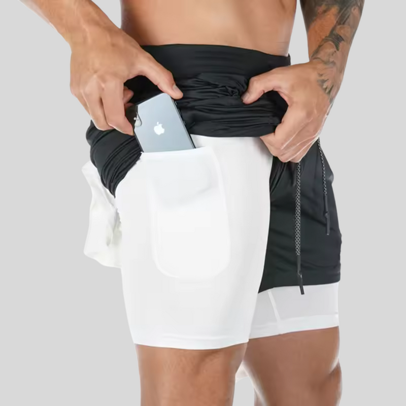 Laden Sie das Bild in Galerie -Viewer, Mann in Sportshorts mit Smartphone-Tasche, zieht schwarzes Oberteil hoch. Fitnessmode, praktische Sportbekleidung, Handyhalterung, Herren-Shorts.

