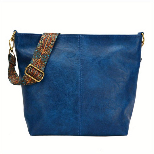 Blaue Ledertasche mit verstellbarem, gemustertem Schultergurt. Modische Damenhandtasche, ideal für Alltag und Freizeit. Hochwertiges Accessoire.