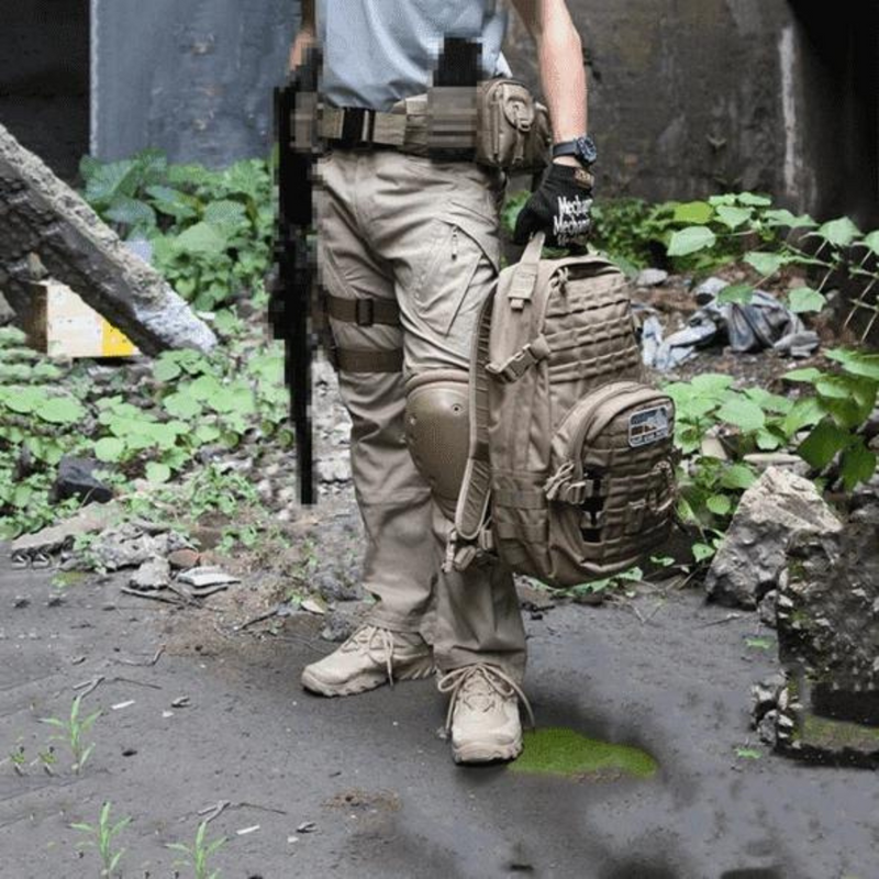 Laden Sie das Bild in Galerie -Viewer, Mann in taktischer Ausrüstung mit Rucksack und Gewehr in urbaner Umgebung. Outdoor-Abenteuer, Survival, Militärkleidung, Ausrüstung.
